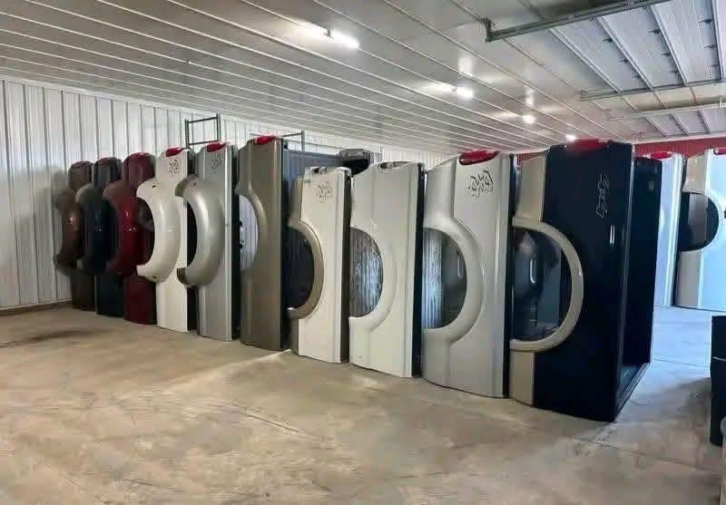 Pickup truck beds stored upright inside a metal building